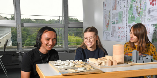 Cover image Students Models Students sit in front of building models.