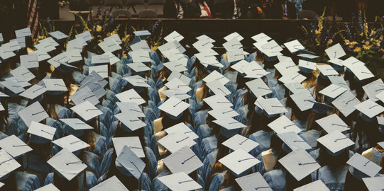 Absolventen Absolvent*innen sitzen zusammen.