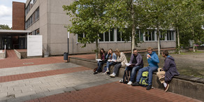 Campus South Students sit on a wall and exchange ideas.