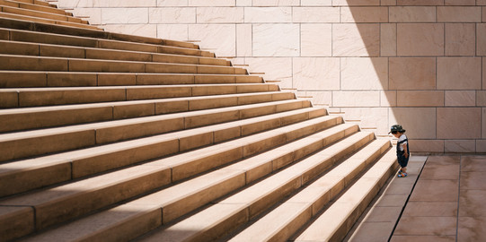 Treppen Kleines Kind steht vor langer Treppe mit großen Stufen.