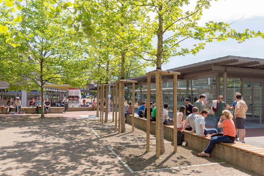 Rudolph-Chaudoire-Pavillion auf dem Campus Süd Dieses Bild zeigt den Rudolph-Chaudoire-Pavillion auf dem Campus Süd im Sommer mit einigen Studierenden im Vordergrund.