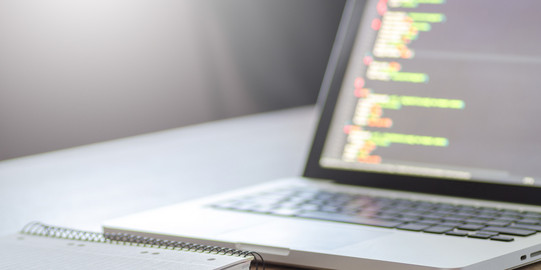 Arbeitsplatz mit Laptop und Notizen Foto eines Laptops und Notizbuches auf einem Schreibtisch.